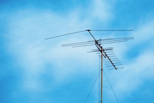 Television antenna on cloudy blue sky