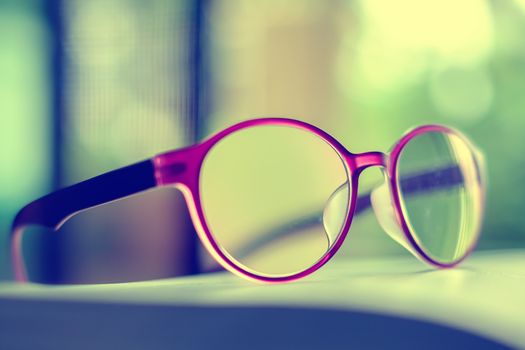 Eyeglasses placed on the book, extremely DOF with vintage retro color tone