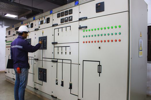 Engineer checking and monitoring the electrical system in the control room