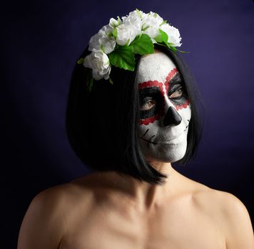 Young beautiful girl with traditional mexican death mask. Calavera Catrina. Sugar skull makeup. girl dressed in a wreath of white roses 