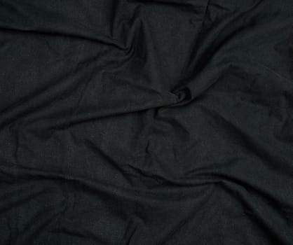 fragment of black cotton fabric with waves, full frame, close up