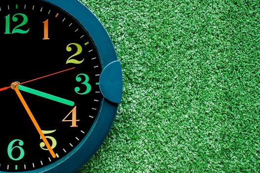 Clock on the plastic artificial green grass