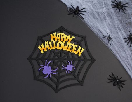 white spider web with black spiders, black background, close up