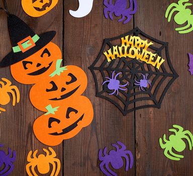 spider and orange pumpkin felt figures on a brown background, Halloween festive backdrop