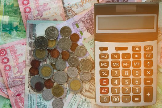 Calculator on Thai baht money banknotes and coins, business and finance concept
