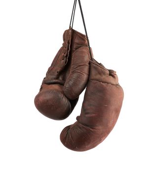 pair of very old vintage brown leather boxing gloves hanging on a black rope, object isolated