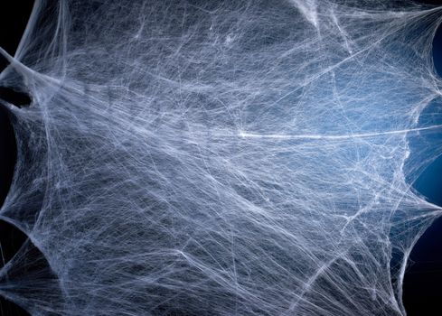 stretched white web with blue backlight, background for the holiday Halloween, copy space