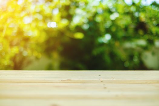 Wood table top on burred green natural background, selective focus and added color filter