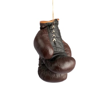 pair of very old vintage brown leather boxing gloves hanging on a rope, object isolated