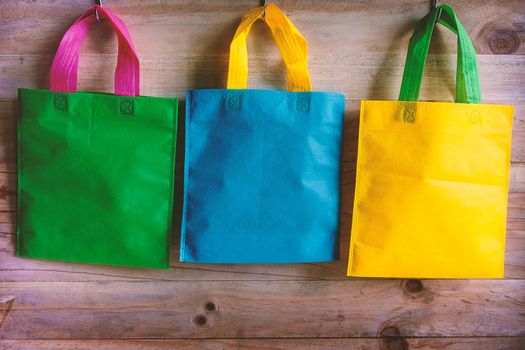 Colorful bags hanging on wooden wall