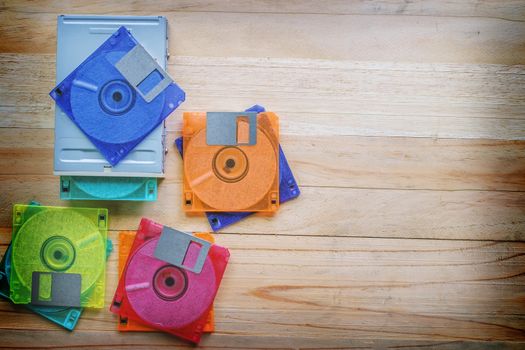 Floppy disk drive and diskettes on wooden table, old technology and legacy industrial computer equipment