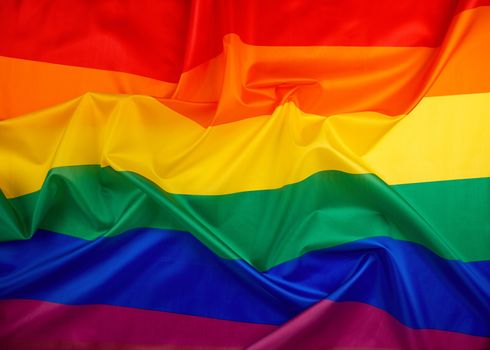 textile rainbow flag with waves, symbol of freedom of choice of lesbians, gays, bisexuals and transgender people, LGBT culture