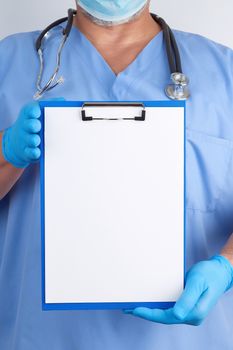 doctor in blue uniform and latex gloves holds a green holder for sheets of paper, empty space for writing text, white background