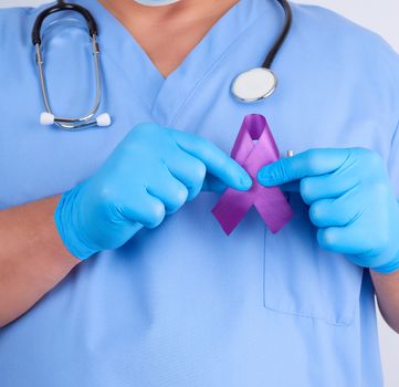 doctor in blue uniform and latex gloves holds a purple ribbon as a symbol of early research and disease control, Alzheimer's disease, cystic fibrosis, lupus, pancreatic cancer, sarcoidosis