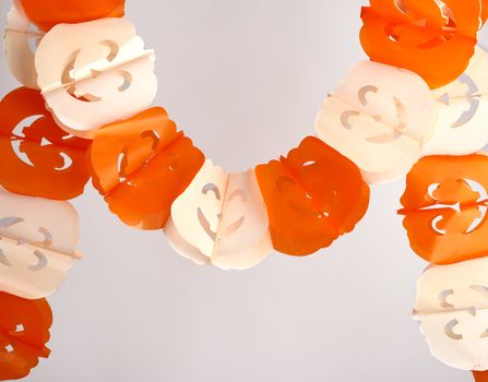 plastic garland on with carved figures of pumpkins, object is isolated on a white background, backdrop for Halloween