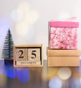 wooden retro calendar from blocks, Christmas decorative tree and cardboard boxes with gifts, white background