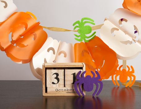 wooden calendar of cubes, garland of pumpkins and spiders, Halloween celebration October 31