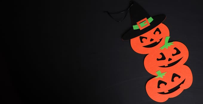 orange pumpkin felt figures on a black background, Halloween festive backdrop