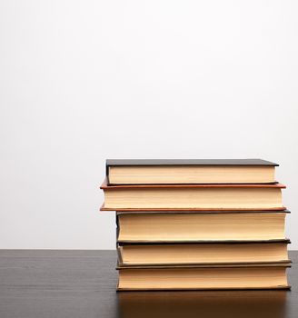 stack of books on a black table, white background, copy space