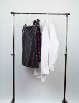 black women's blouse with red sequins, white men's shirts hang on a white iron hanger, sale concept