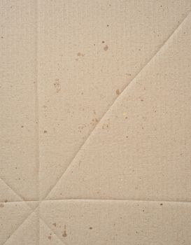 fragment of a brown paper sheet of a box with greasy stains, close up