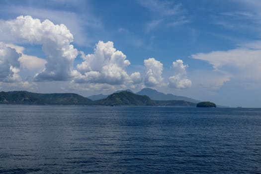 Dramatic looking clouds over sea. Billowing clouds hang over the ocean. Beautiful summer blue sky and white clouds over calm sea in sunny day. Beautiful cumulus cloud over ocean weather. Background.