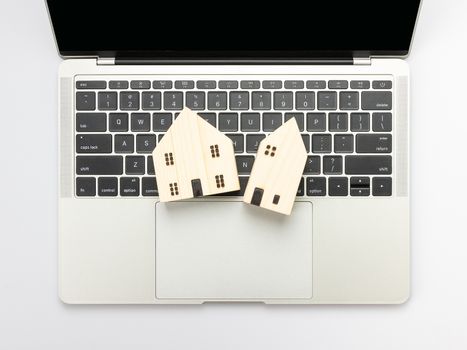 Modern white office desk table with laptop computer and House model for home loans concept.