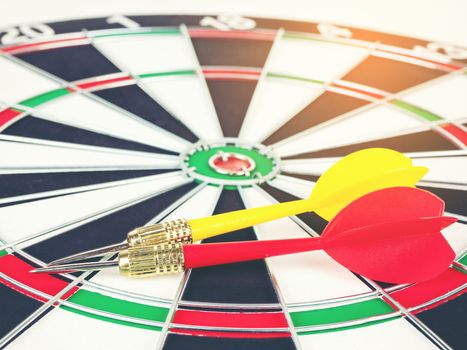 Red and yellow Dart arrows and dartboard with light