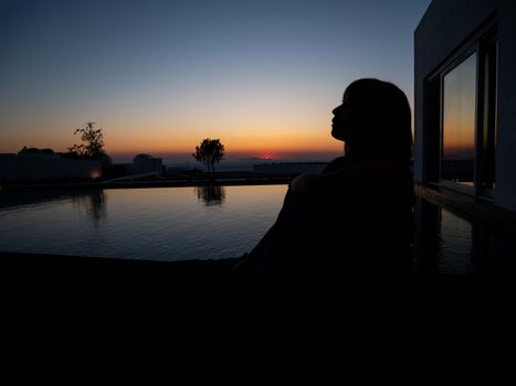 Sad woman silhouette worried at sea and sunset.