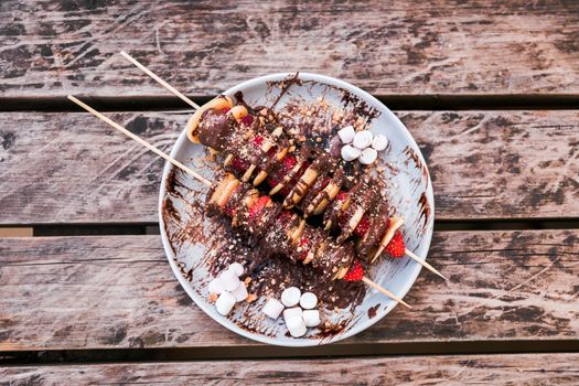 Homemade mini crepe and strawberry skewers on wooden table