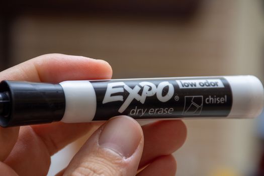 "RAK/RAK/UAE - 02/29/2020: Quality Expo Dry Erase marker, black, with hand holding for whiteboards. Mistakes, remove, education concepts."