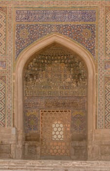 Wall with archway and door with ancient Asian ornament. the details of the architecture of medieval Central Asia