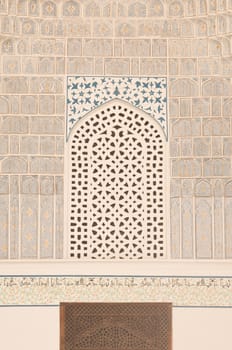 wall with white mosaics and traditional ornament. the details of the architecture of medieval Central Asia