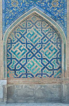 Wall with an arch in traditional Asian mosaic. the details of the architecture of medieval Central Asia