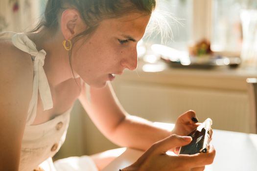 Young woman playing online games on a mobile phone