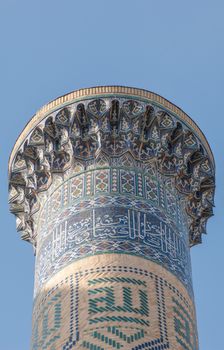 The top of the tower with a mosaic of quite ancient Asian buildings. the details of the architecture of medieval Central Asia