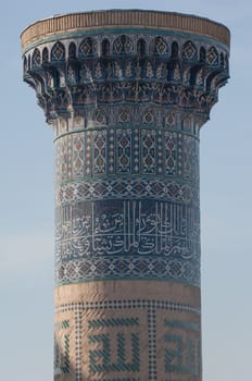 Closeup of the top of the tower with a mosaic of quite ancient Asian buildings. the details of the architecture of medieval Central Asia