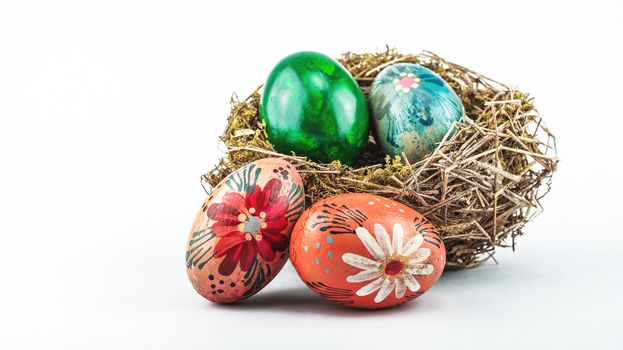 Old Easter eggs in bird nest isolated on a white background.