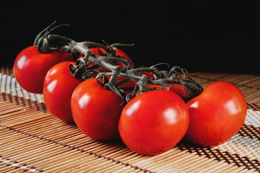 tomatoes on a wooden coaster with black background