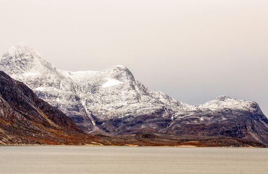 Snow topped mountains with Ukkusissat Little Malene peak and sea in the foreground, Nuuk, Greenland