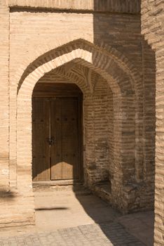 Wooden door with ancient traditional Asian ornamentation and mosaics. the details of the architecture of medieval Central Asia