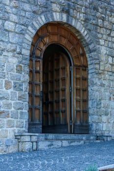 Mediterranean architecture. High vaulted doors in the stone wall of an old building.