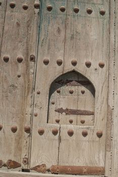 Old wooden door with metal rivets in Bukhara, Central Asia.