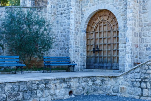 Mediterranean architecture. High vaulted doors in the stone wall of an old building.