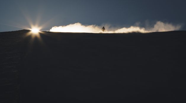 Skier enjoying an early morning in slopes at the Austrian Alps with a nice sunshine backlight