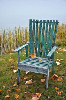 Old wooden green chair by the lake