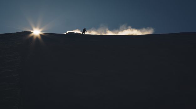 Skier enjoying an early morning in slopes at the Austrian Alps with a nice sunshine backlight