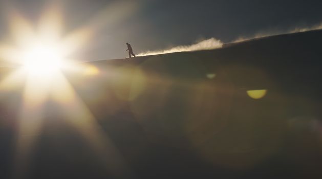 Snowboarder enjoying an early morning in slopes at the Austrian Alps with a nice sunshine backlight