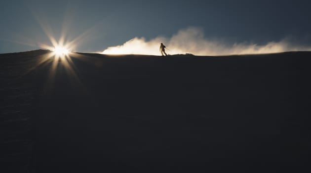 Skier enjoying an early morning in slopes at the Austrian Alps with a nice sunshine backlight
