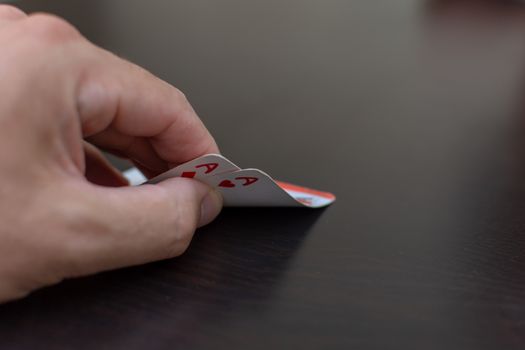 RAK, RAK/UAE - 4/20/2019: "Pocket (pair) of aces in a poker game with a hand and black table making a likely bet to win a hand in this card game."